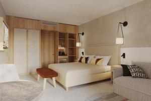 um quarto com uma cama branca e um sofá em MClub Marmorata em Santa Teresa Gallura