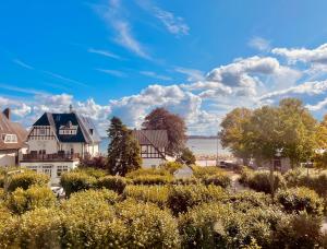 een huis in een dorp met bomen en struiken bij 3SZ Penthaus Luna am Sandstrand mit Meerblick & Balkon in Lübeck