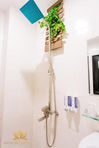 a shower head in a bathroom with a plant at Lotus Village Hotel - 68 Hàng Bồ - by Bay Luxury in Hanoi