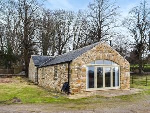 a small stone building with a large window at Southview Barn in Barnard Castle