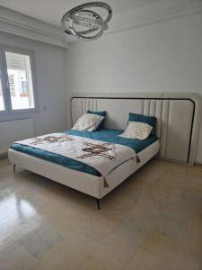 a bedroom with a bed in a white room at Appartement proche de la plage à 200 M restaurant Piccolino in Dar el Koudia