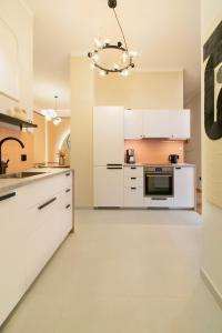 a kitchen with white cabinets and a chandelier at Central Apartments Warszawska Street in Krakow
