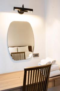 a mirror on a wall with a chair and a bed at Sukhothai Residence Ruam Ruedi in Bangkok