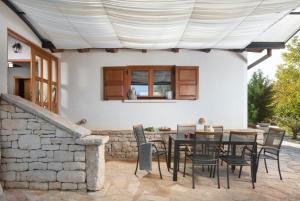 a patio with a table and chairs under awning at Bella Collina in Krajcar Brijeg - Haus für 4-5 Personen in Žminj