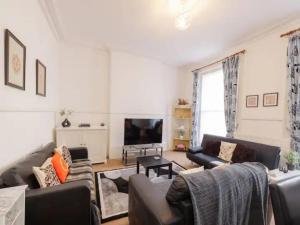 sala de estar con sofás y TV de pantalla plana. en Pass the Keys Spacious 3 Bed Flat Near Kings Cross and Camden, en Londres