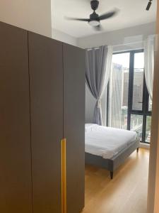 um quarto com uma cama e uma grande janela em Sentral Suites KL Sentral by NomadNest em Kuala Lumpur