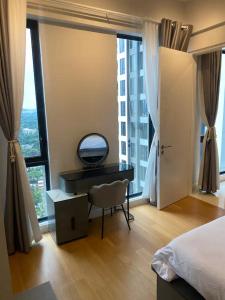 um quarto com uma secretária e uma grande janela em Sentral Suites KL Sentral by NomadNest em Kuala Lumpur