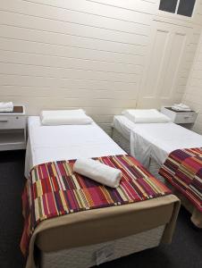 a room with two beds with towels on it at GRAND CENTRAL HOTEL PROSERPINE in Proserpine