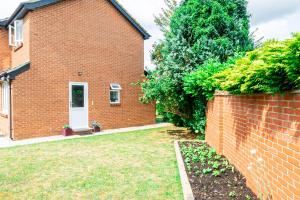 a brick house with a white door and a yard at Earley Luxury Ensuite Room with private entrance in Reading