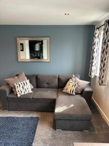 a living room with a couch and a mirror at Cathedral Apartment in Lichfield