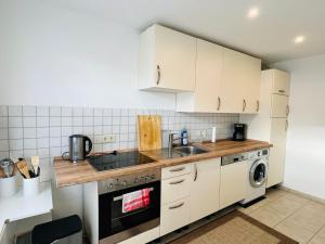 a kitchen with white cabinets and a sink and a dishwasher at Ferien/Monteurwohnung Hodenhagen in Hodenhagen