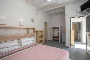 LivadiaにあるHotel Iriniのピンクベッド1台とクローゼット付きのベッドルーム1室