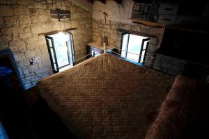 ein großes Bett in einem Zimmer mit zwei Fenstern in der Unterkunft Atelier.Germana in CastellʼUmberto Vecchio