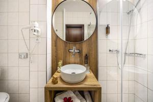 ein Badezimmer mit Waschbecken, Spiegel und Dusche in der Unterkunft Hotel Park in Piešťany