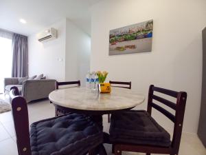 een tafel en stoelen in een kamer met een woonkamer bij Cozy Home at Near Centre and Airport @ Galacity in Kuching