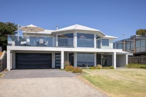 una grande casa bianca con un grande garage di Seaside Sanctuary - Pool and Beachfront a Ventnor