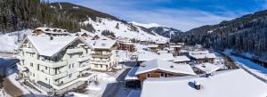 uma vista aérea de uma estância de esqui com edifícios cobertos de neve em Apartments Kolmblick em Gerlos