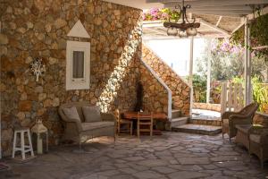 a patio with chairs and a stone wall at Hotel Irini in Livadia