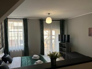 een woonkamer met een bed en een televisie bij H-Apartamenty Junior in Nowa Sól