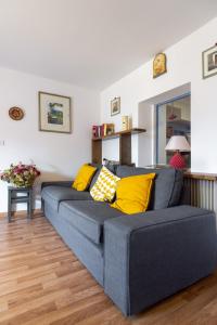 a blue couch with yellow pillows in a living room at DolomiApartments - Appartamento Girasole in Predazzo