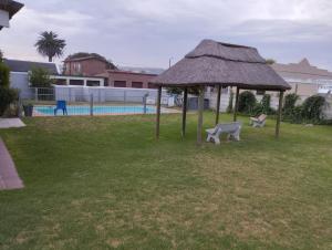 a gazebo with a bench in a yard at Bellevue Resort Stilbaai Nr.7 in Stilbaai