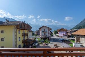 a view from a balcony of a town with mountains at DolomiApartments - Appartamento Girasole in Predazzo