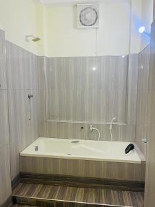 a bath tub with a hose in a bathroom at DreamCity Hotel in Kilinochchi