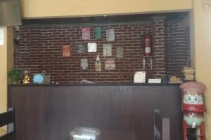 a bar with a brick wall in a restaurant at OYO 93759 Yume Guest House in Midang