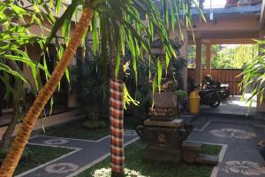 a palm tree in the middle of a courtyard at OYO 93759 Yume Guest House in Midang