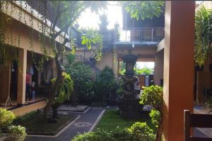 a courtyard with a clock in the middle of a building at OYO 93759 Yume Guest House in Midang