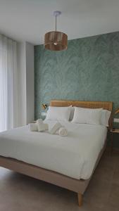 um quarto com uma grande cama branca e uma parede verde em Imperial Apartamentos Valencia em Valência