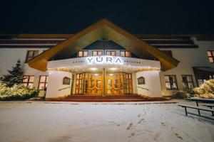 un edificio con un cartel en la parte delantera en YURA hotel Čeladná -BAZÉN A SAUNA ZDARMA, en Čeladná