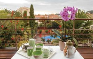 einen Tisch mit Tassen und Blumen auf dem Balkon in der Unterkunft Amazing Home In Tossa De Mar in Tossa de Mar + 31 Fotos