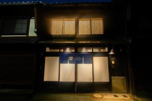 uma frente de loja com um sinal azul e branco em Auberge Homachi Mikuniminato em Sakai