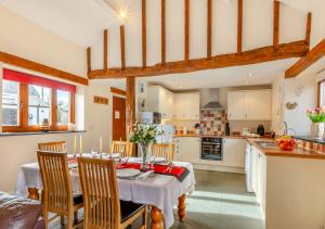una cucina e una sala da pranzo con tavolo e sedie di Oriel Cottage a Bittadon
