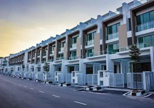 una fila de edificios de apartamentos al lado de una calle en Three Storey Garden Home at Bukit Gambir 18ppl, en Gelugor
