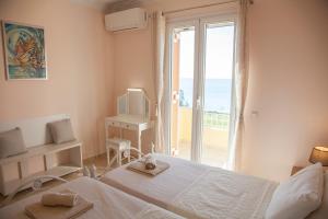 a bedroom with a bed and a window with the ocean at Grand View Retreat at "Avythos" Βeach in Kaligata