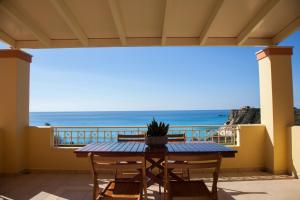 una mesa y sillas en un balcón con vistas al océano en Grand View Retreat at "Avythos" Βeach, en Kaligata