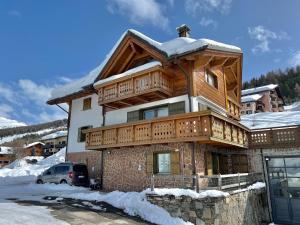 a large wooden house with snow on the roof at Appartamento Levanto in Livigno