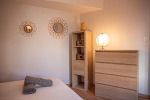 - une chambre avec un lit, une commode et un miroir dans l'établissement La maison rue Nadaud, au pied des remparts, à Carcassonne