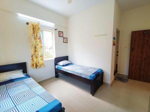 um quarto com 2 camas e uma janela em Vishnu Living rooms and villas em Kelambākkam