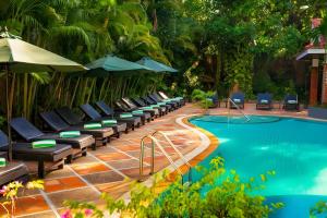 uma piscina de resort com espreguiçadeiras e guarda-sóis em ANGKOR TRAILS Residence em Siem Reap