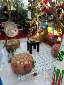 eine Terrasse mit einem Tisch und Stühlen auf einem Teppich in der Unterkunft peace garden hostel & camp in Luxor