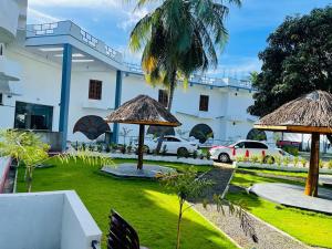 a building with a grass yard with umbrellas at DreamCity Hotel in Kilinochchi