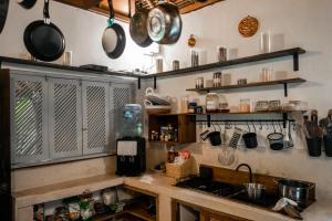 une cuisine avec des casseroles et des poêles suspendues au-dessus d'un comptoir dans l'établissement My Secret Home, à Seminyak