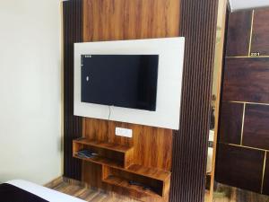 TV de pantalla plana colgada en una pared de madera en Hotel Vimal Ganga en Rishīkesh