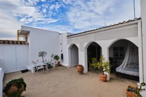 eine Terrasse mit einem Tisch und Stühlen in einem weißen Gebäude in der Unterkunft Penthouse Inlakesh in Valencia