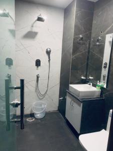 y baño con ducha, lavabo y aseo. en Hotel Vimal Ganga, en Rishīkesh