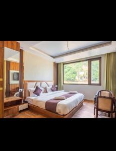 Un dormitorio con una cama grande y una ventana en Hotel Vimal Ganga en Rishīkesh