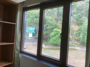 a window with a view of a yard at Hotel Vimal Ganga in Rishīkesh